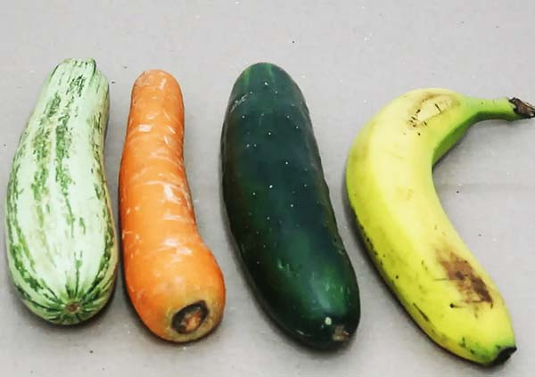 imagem de uma bana próxima de 3 legumes abobrinha cenoura e pepino