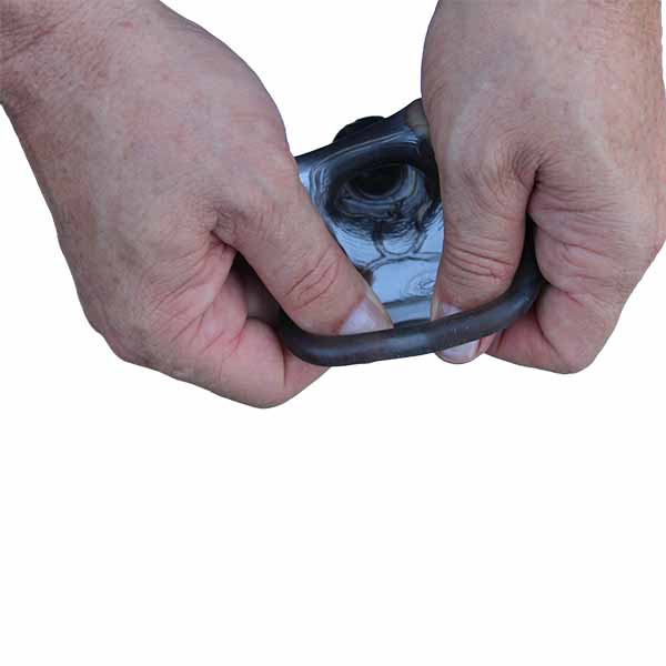mão masculina demonstrando a elasticidade capa peniana preta em silicone com anel escrotal