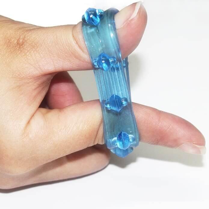 dedos femininosesticando anel peniano sem vibração azul para demonstrar a elasticidade