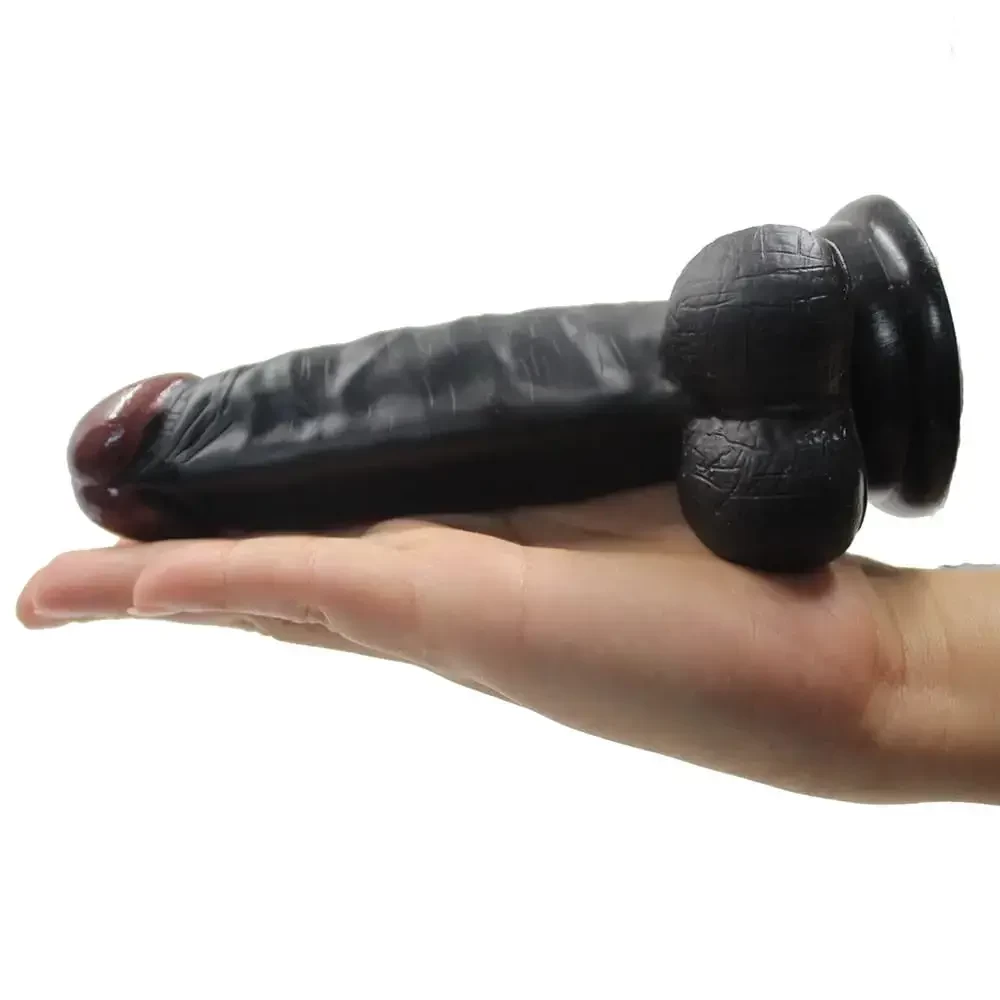 Imgem de pênis preto de silicone sobre uma mão feminina