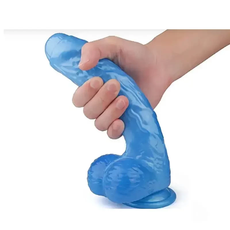 Imagem de uma mão masculina segurando pênis de silicone com ventosa e escroto medindo 16cm na cor azul